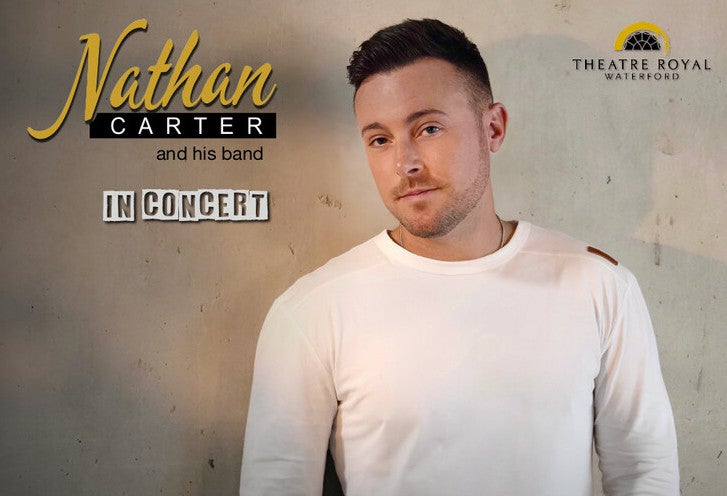 A slightly smiling man in a white top