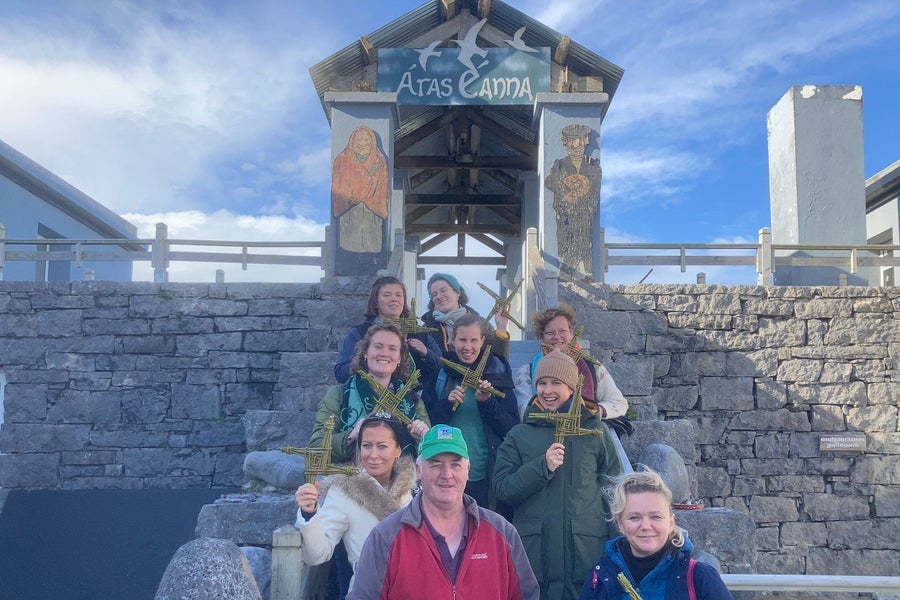 Group of people standing outside the Aras Eanna Arts Centre holding up their Brigids cross