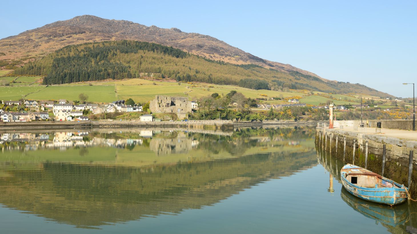 A boat at the harbour at Carlingford Lough with a backdrop of mountains