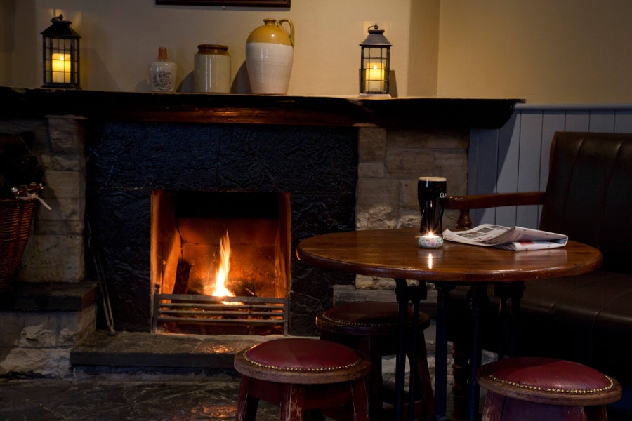 Table and chair next to a fireplace in the bar