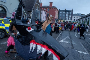 people and puppets in parade