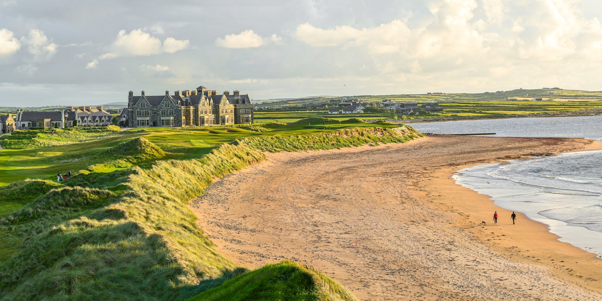 People walking on the beach by Trump International Golf Links and Hotel in Doonbeg, County Clare