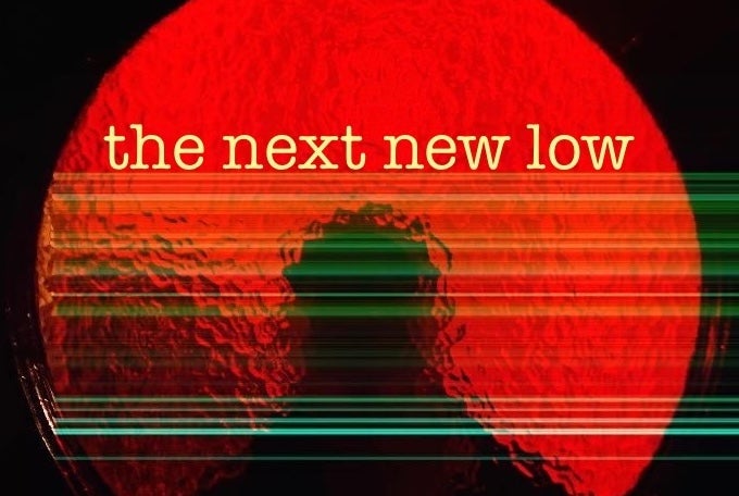 A round circle of red glass with silhouette of person outside against black background.