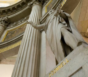 A stone statue set within a grand rotunda framed with columns