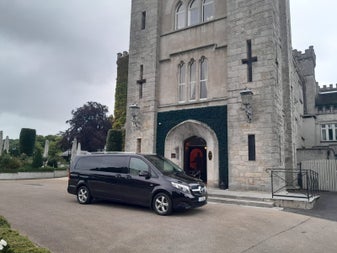 A Top Hat Chauffeurs car parked outside Cabra Castle Hotel