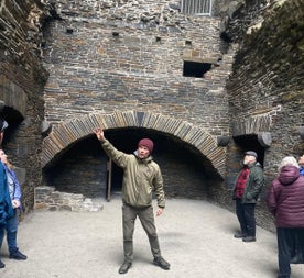 A guide sharing the history of an impressive stone castle interior