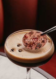 A cocktail decoration is added to the top of an espresso martini