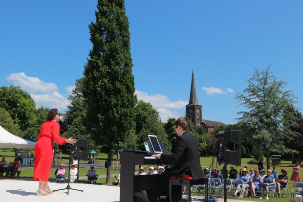 BVOF 2026 - Free Open Air Recital Dungarvan - A person playing a keyboard and a woman singing on a small stage in a park.