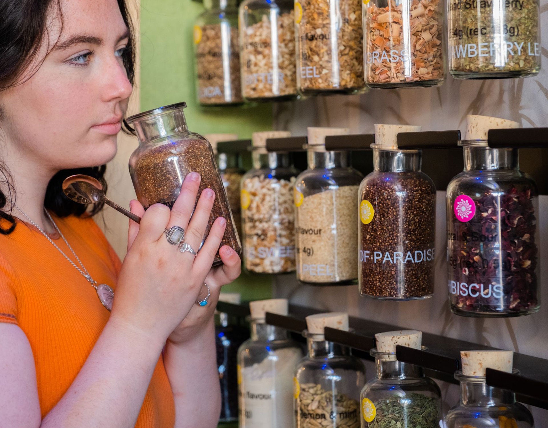 A lady smelling from the jar of the botanicals used to make the gin at Stillgarden Distillery