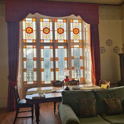 A large room with antique furniture and large stained glass windows