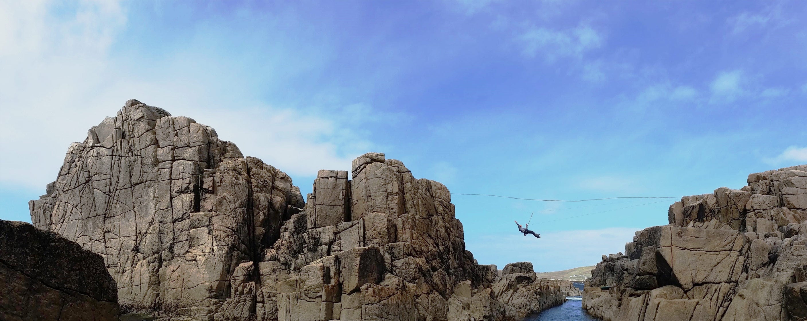 Zip lining between rocks over the sea