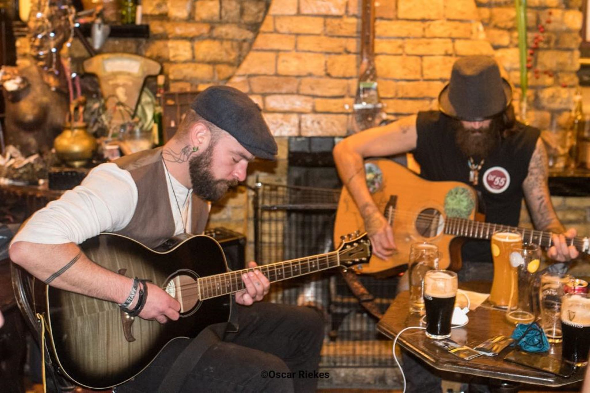Two musicians playing the guitar at a table in the pub
