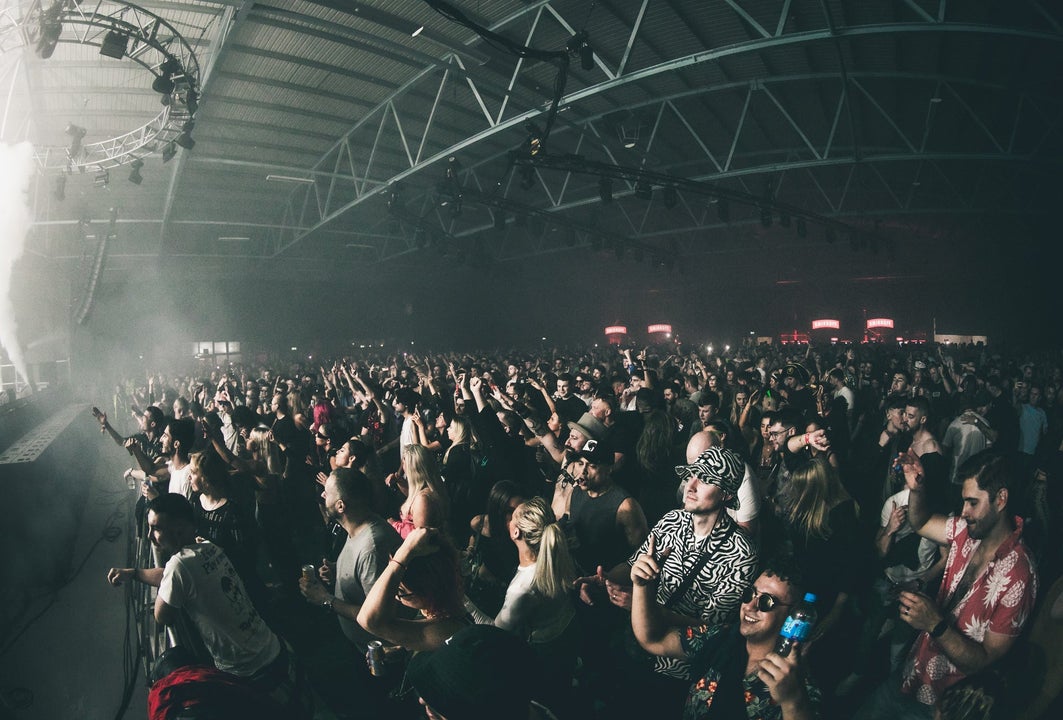 Crowd of young people looking up at a brightly lit stage