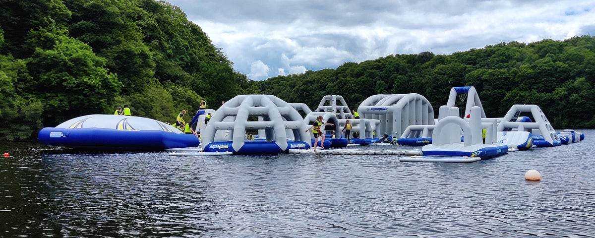 A floating obstacle course on a lake with people on it