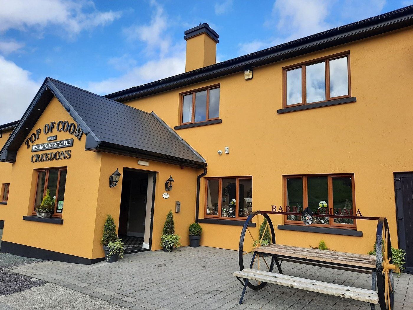 The exterior of a large pub with the name and the family name in prominent signage on the wall
