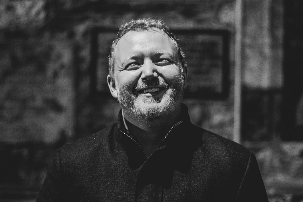 Smiling man in dark coat outdoors