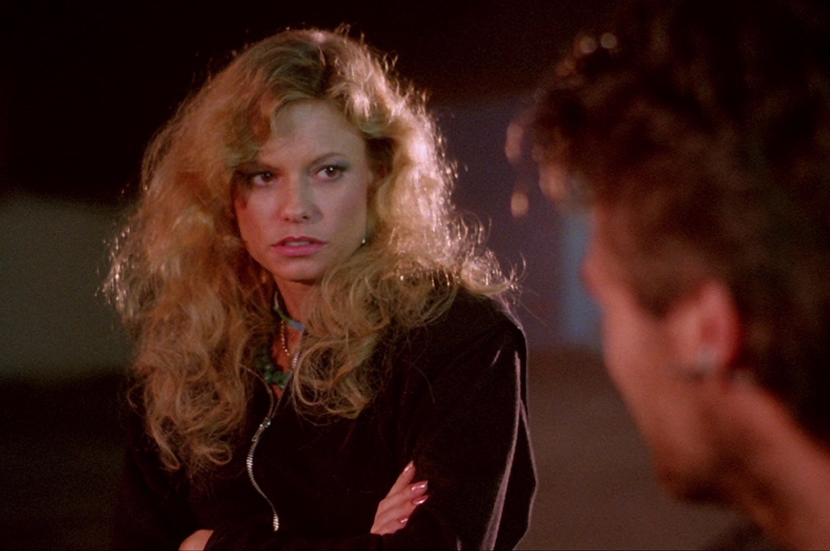 A woman with a wary expression is looking at a man.