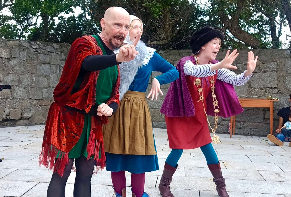 Bloomsday for Kids: The Cat and the Devil - 3 people in colourful costumes performing in a paved area.