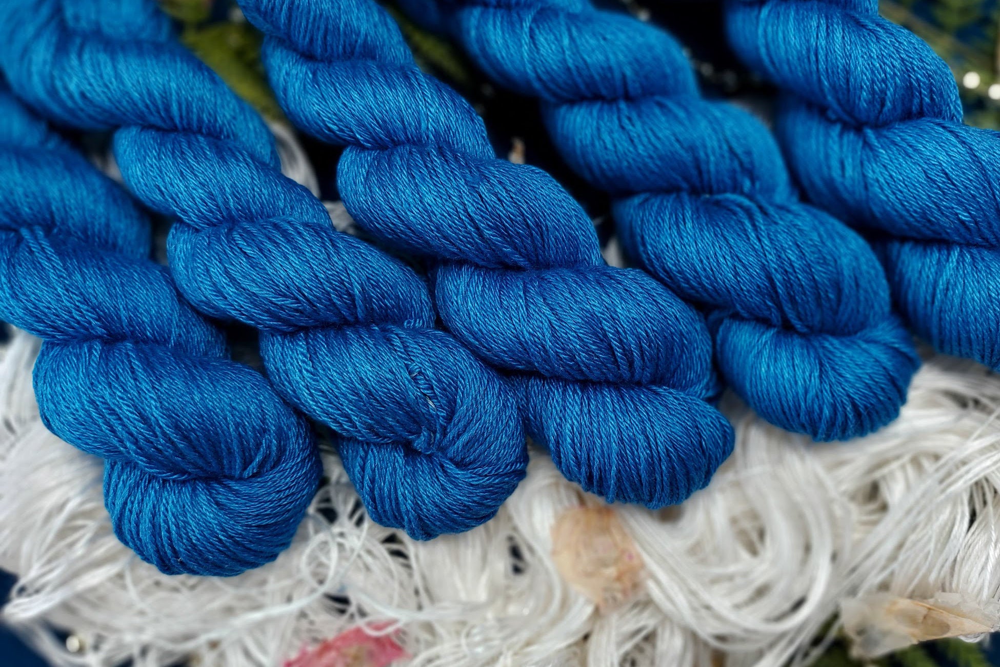Skeins of blue yarn laid out over white yarn