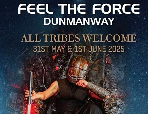 A person with face covered by dark metal mask is seated on rough, rocky throne holding light sabre.