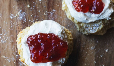 Homemade scones with cream and a dollop of jam on top