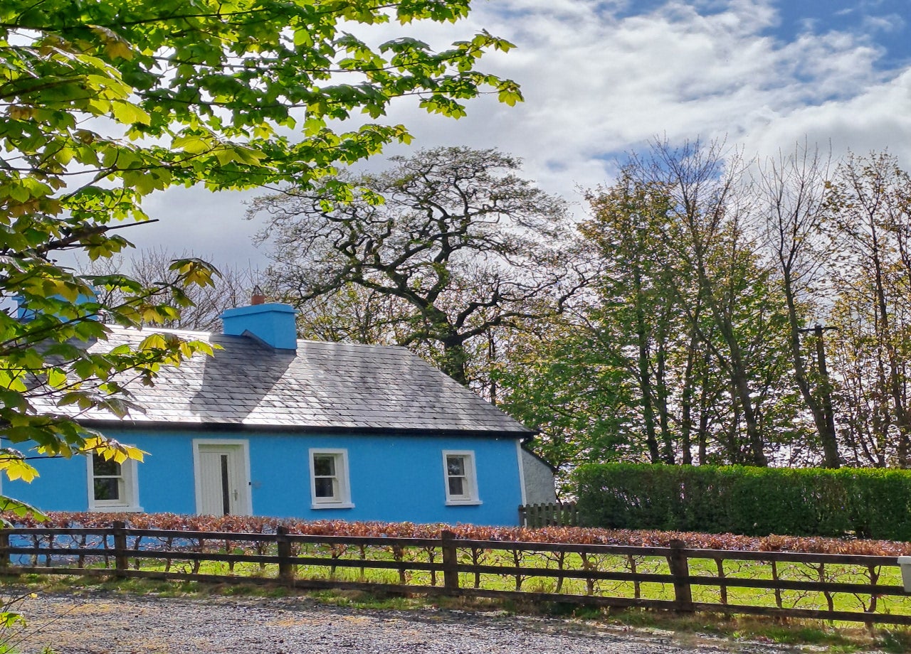 Front view of blue house and gardens
