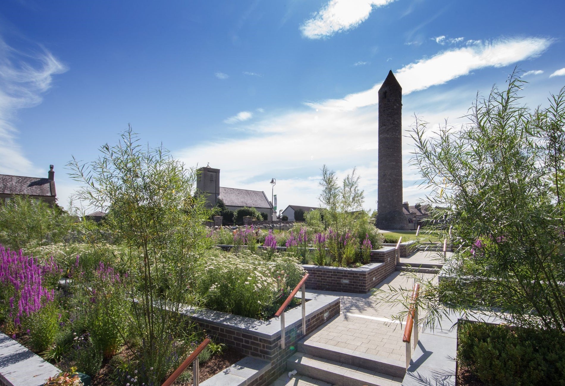 Round tower surrounded by steps flowers and greenery