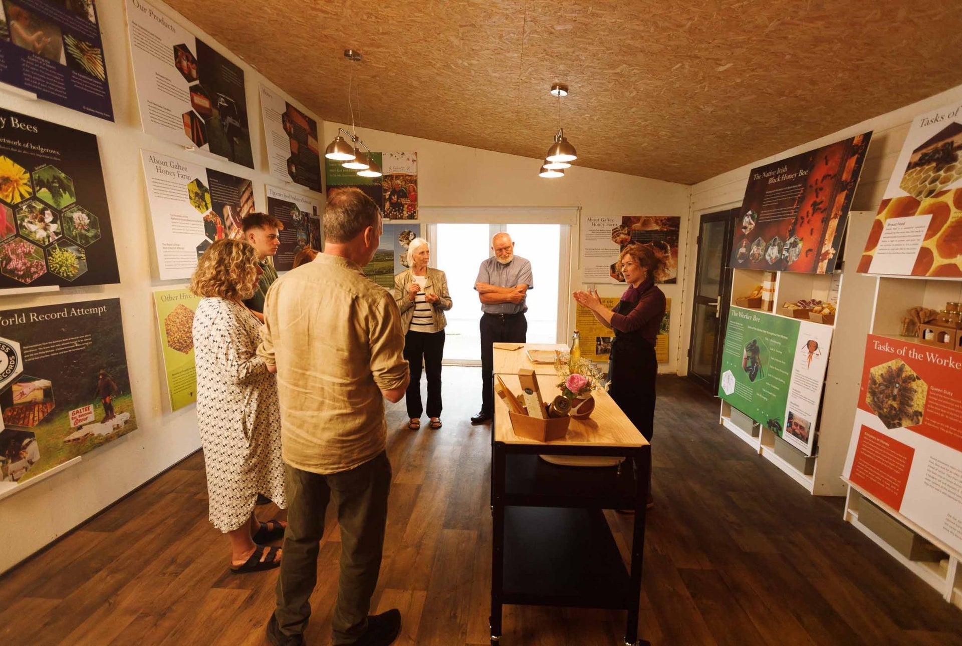 A group of people indoors at a bee and honey demonstration