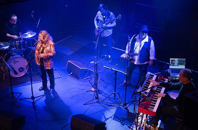 Looking down on a band playing on a small stage, lit with blue light