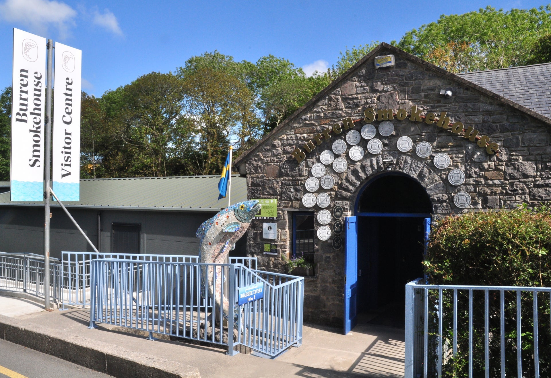 Exterior view of the entrance doorway with a large salmon mosaic to the left of the doorway