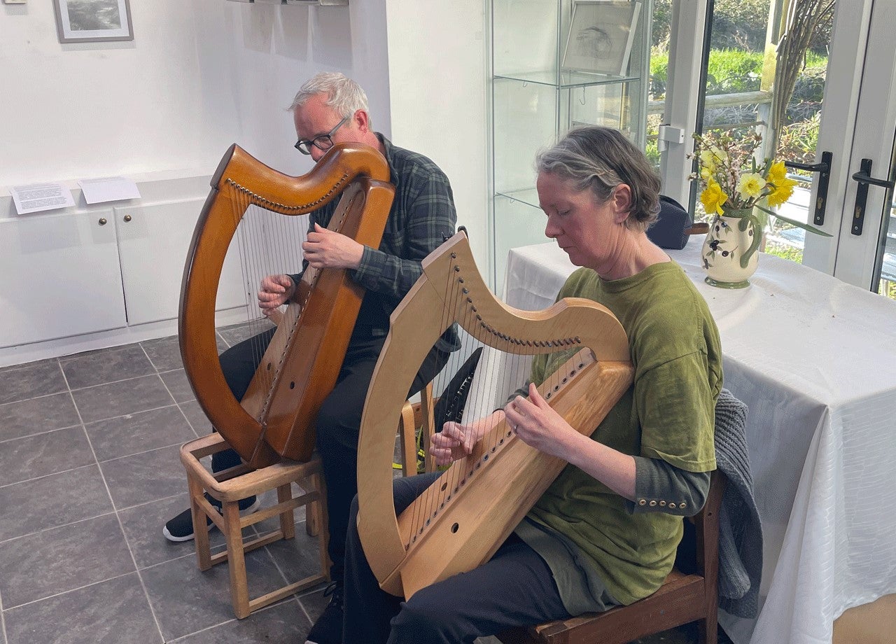 Two people playing harp at the Teach Ban Gallery