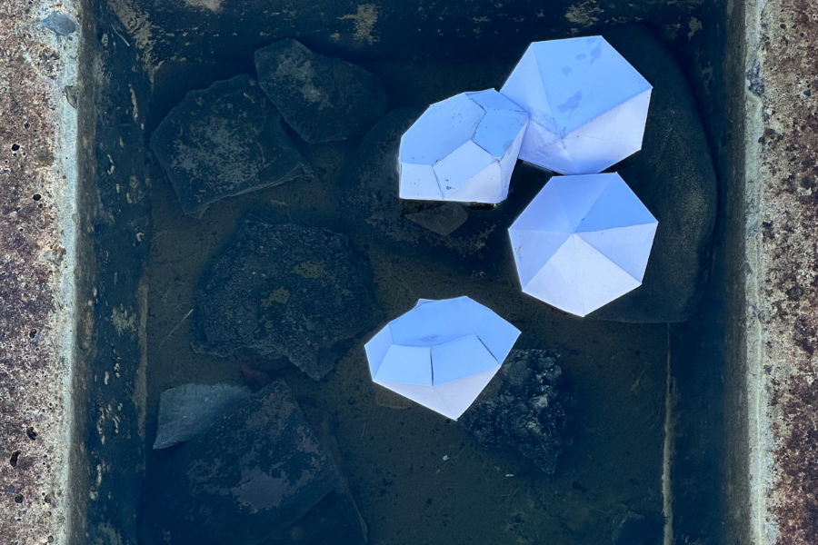 Looking down at 4 pale blue diamond shapes on dark square background.