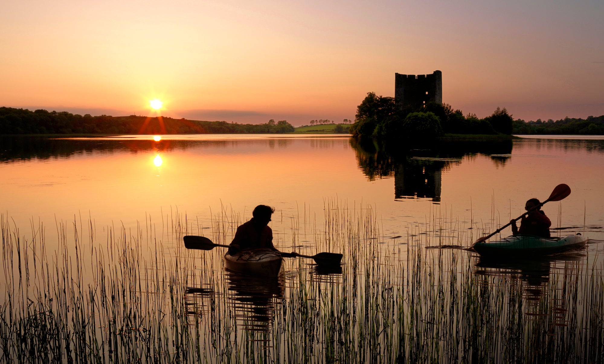 People kayaking in Lough Oughter, Co Cavan at sunset