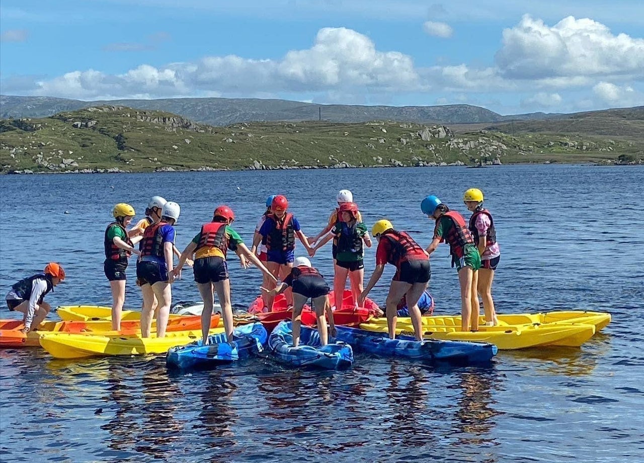 A group of girls on blue and yellow kayaks on the water