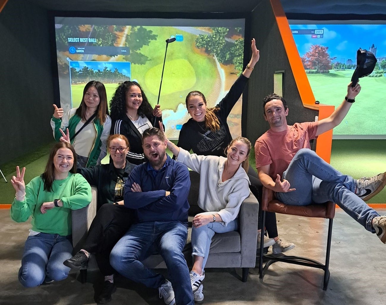 Group of people sitting and standing in front of a screen
