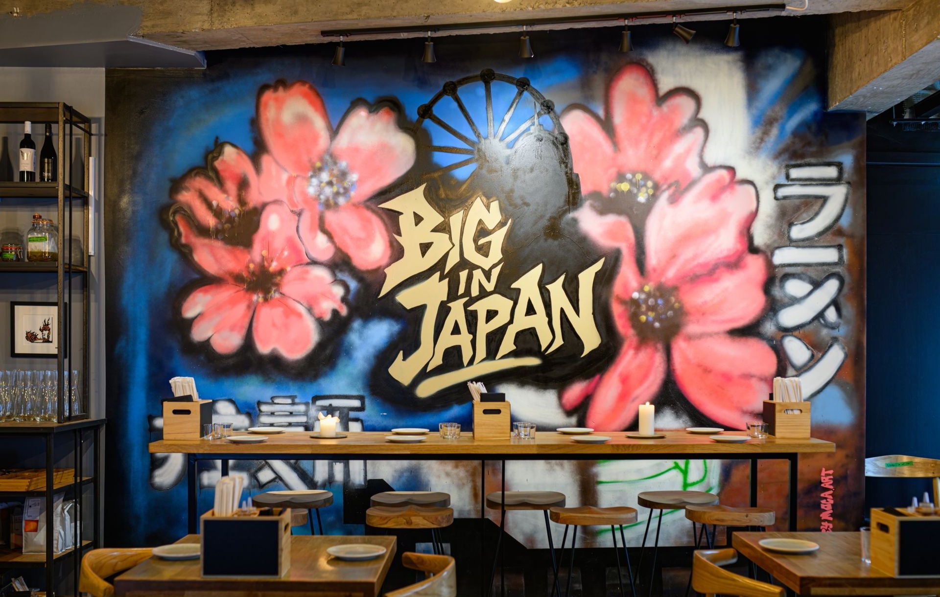 Dining area in the restaurant with a colourful Japanese mural on the wall