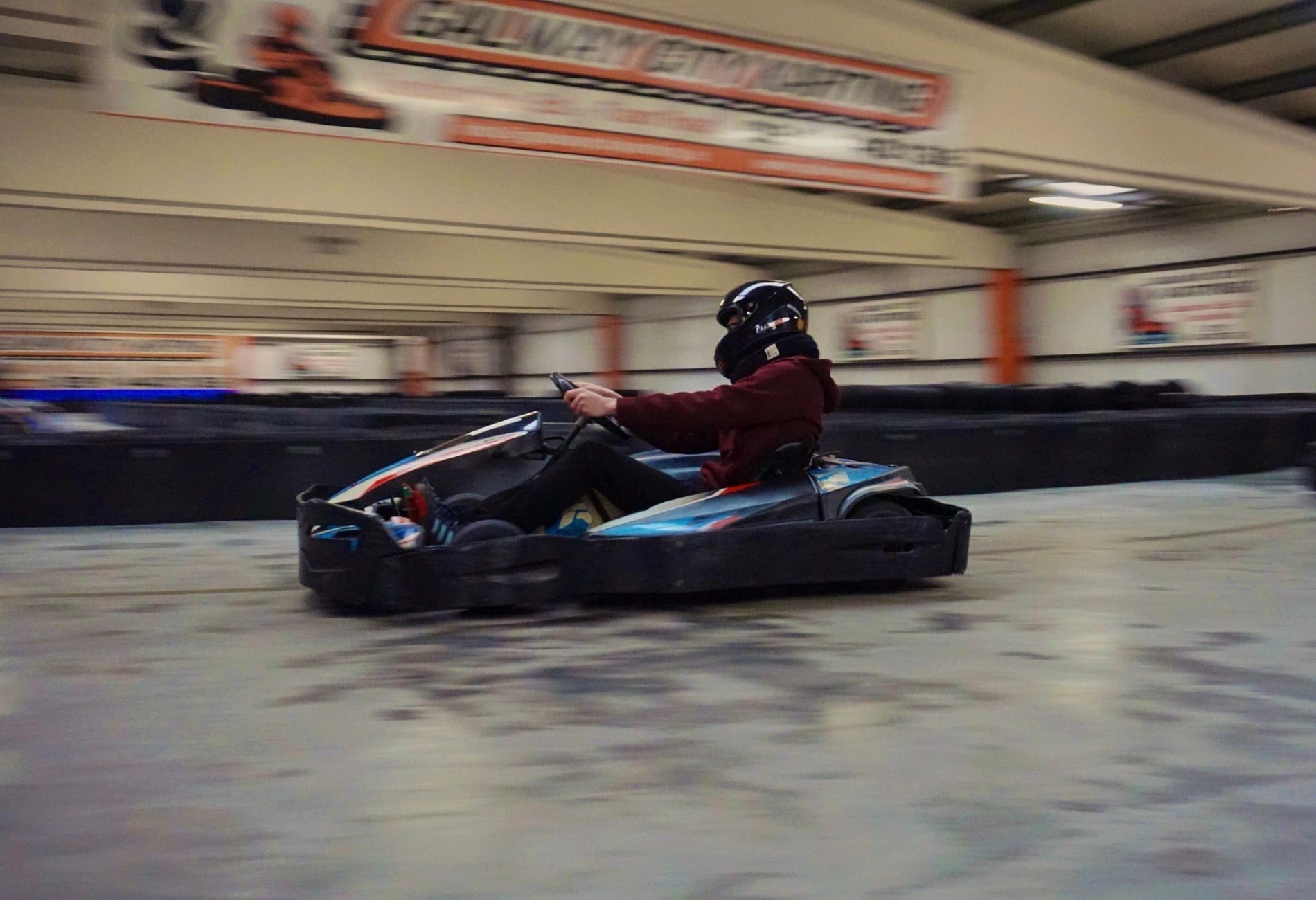 Image of a person driving a kart on an indoor track