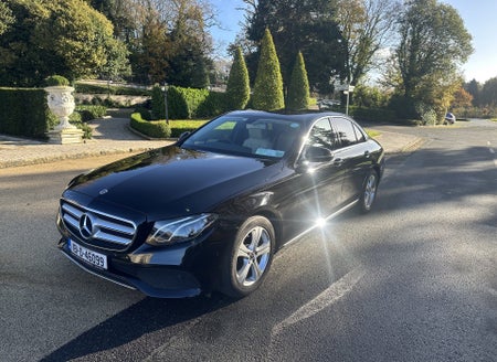 A gleaming limousine parked on a quiet residential street