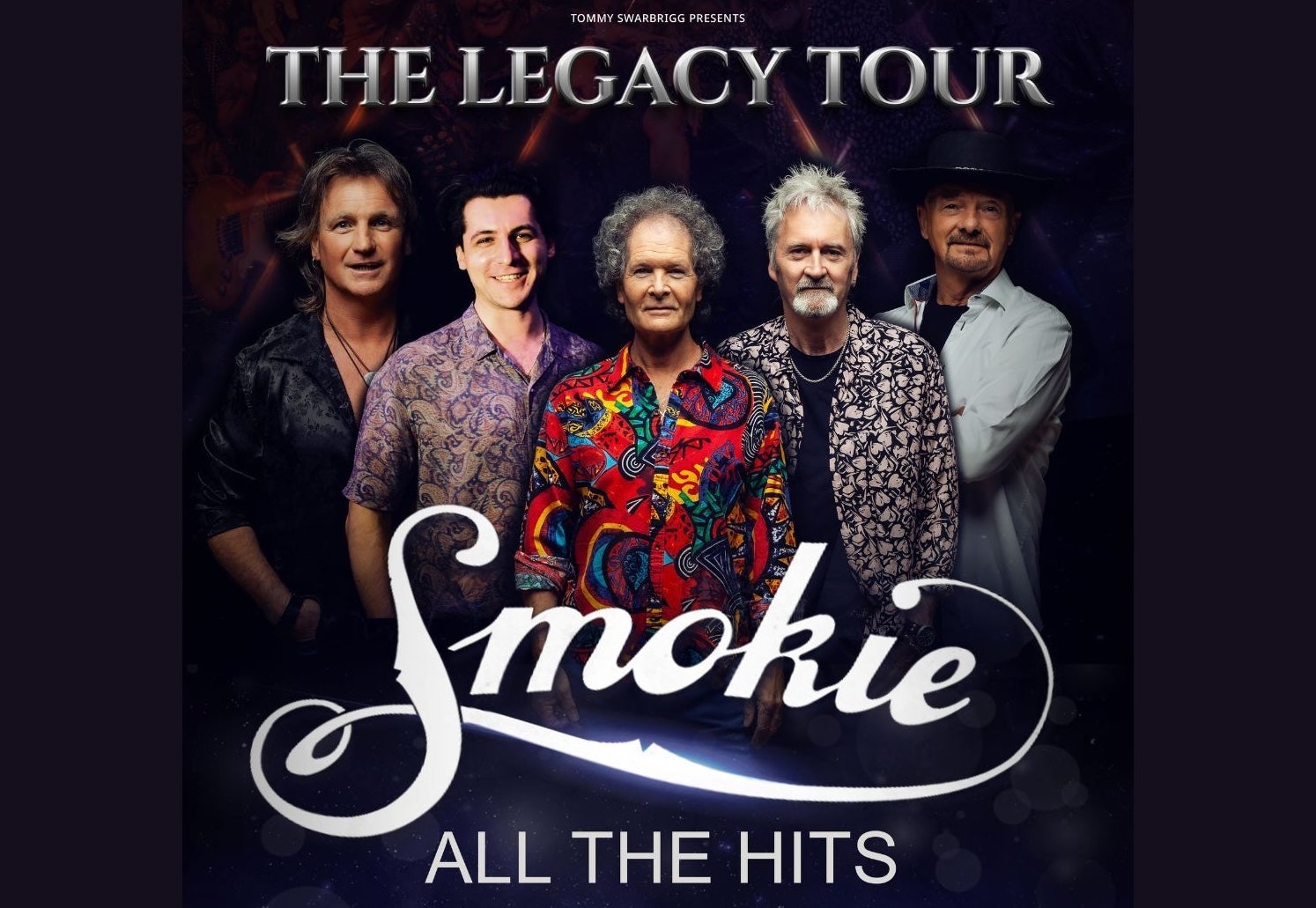 A group of 5 gently smiling men, some wearing patterned shirts, against black background.