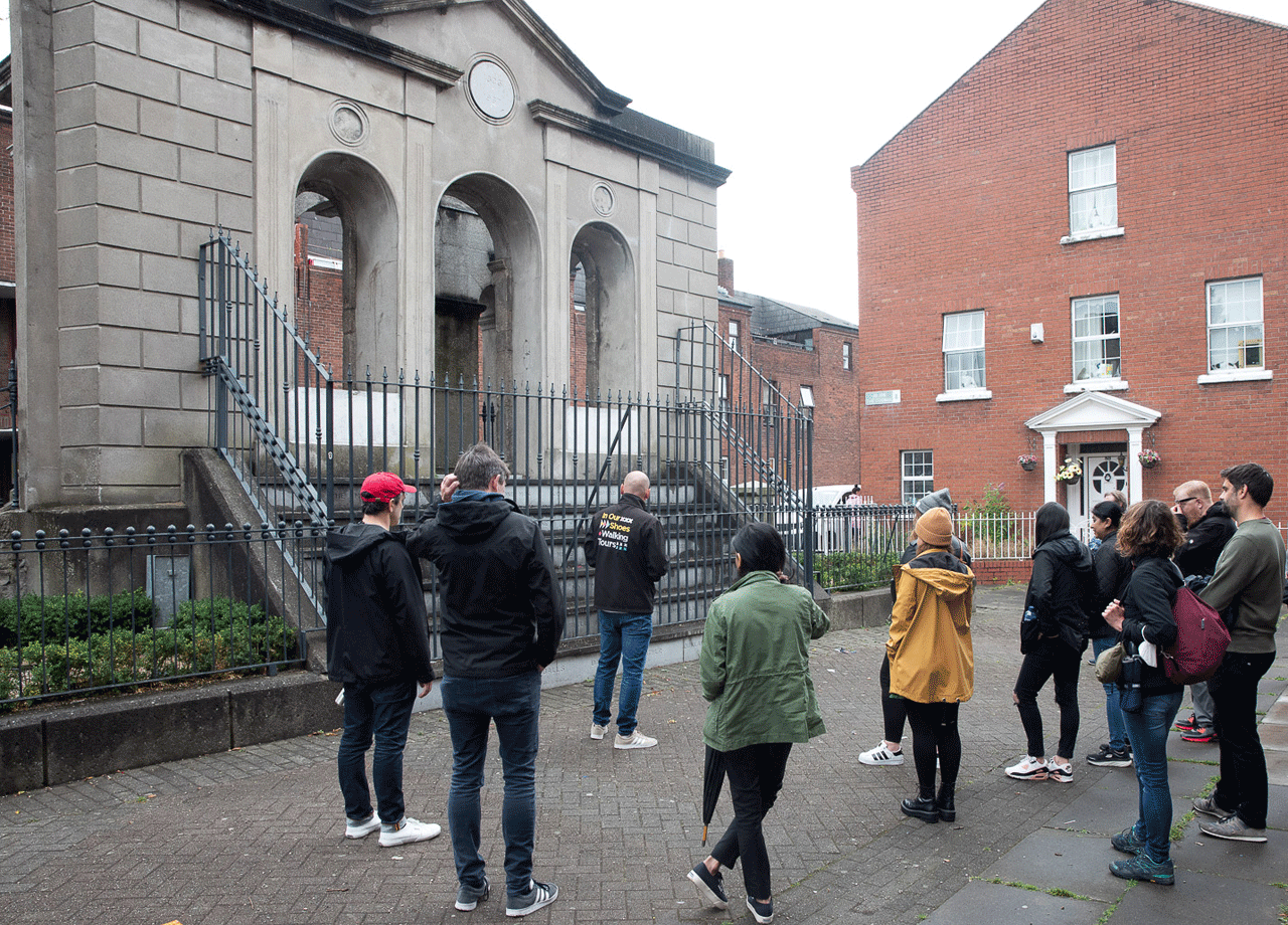 Group on a walking tour with the Coombe hospital monument in the background
