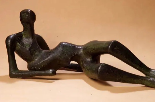 Dark bronze figure half propped up on elbows, the rest laid out, against pale orange background.