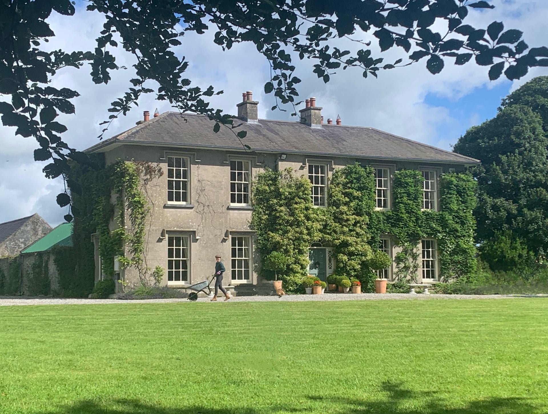 The exterior of a large country Georgian house with a lawn area to the front