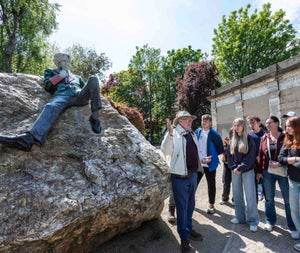 A male tour guide giving a tour to a large group of people