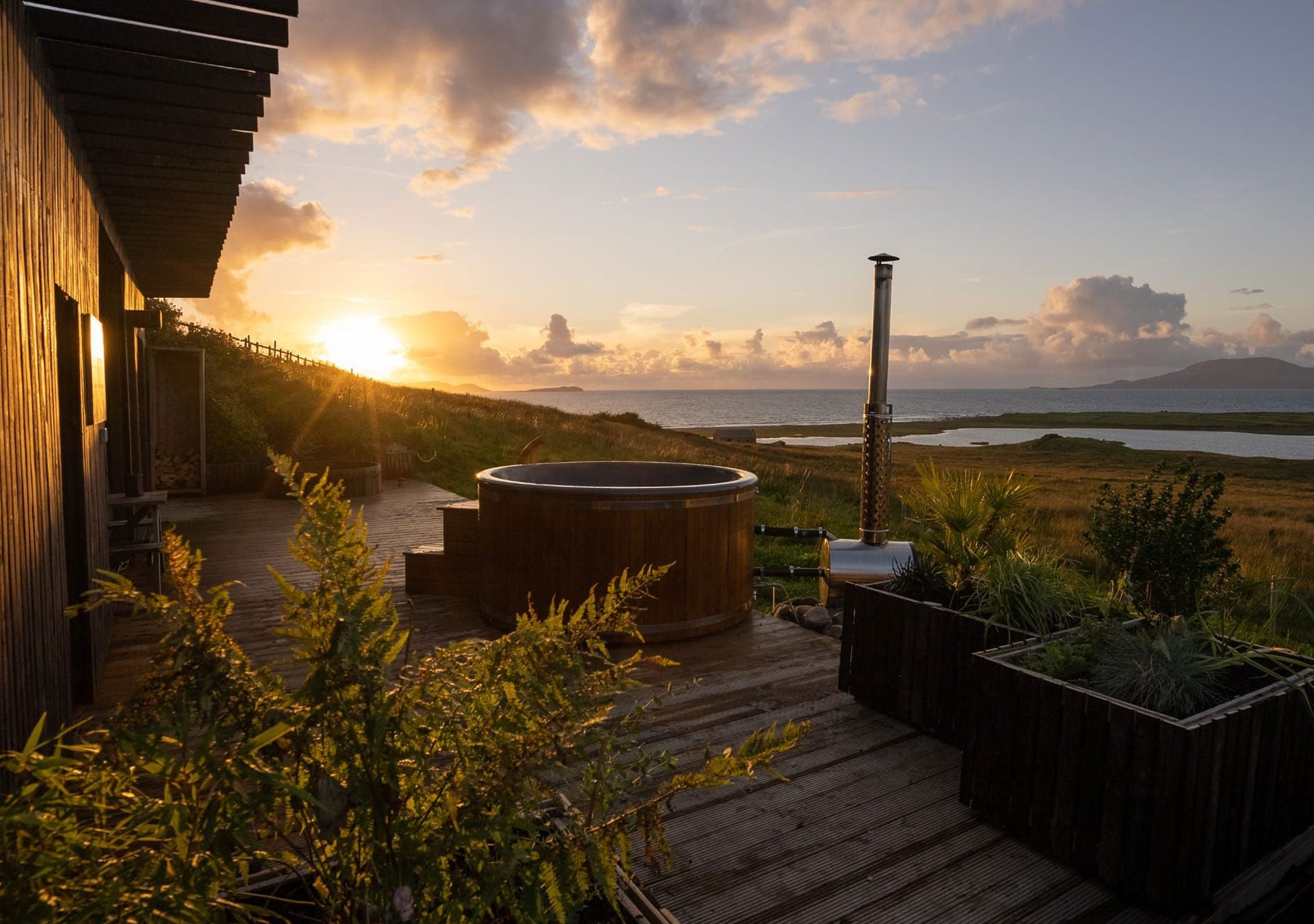 The hot tub with sea view and sunset in the background
