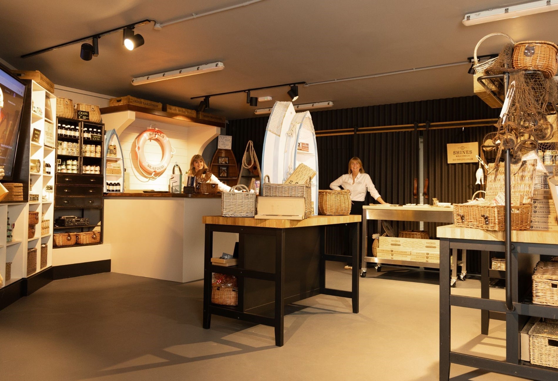 Two people standing at the back of a shop surrounded by products