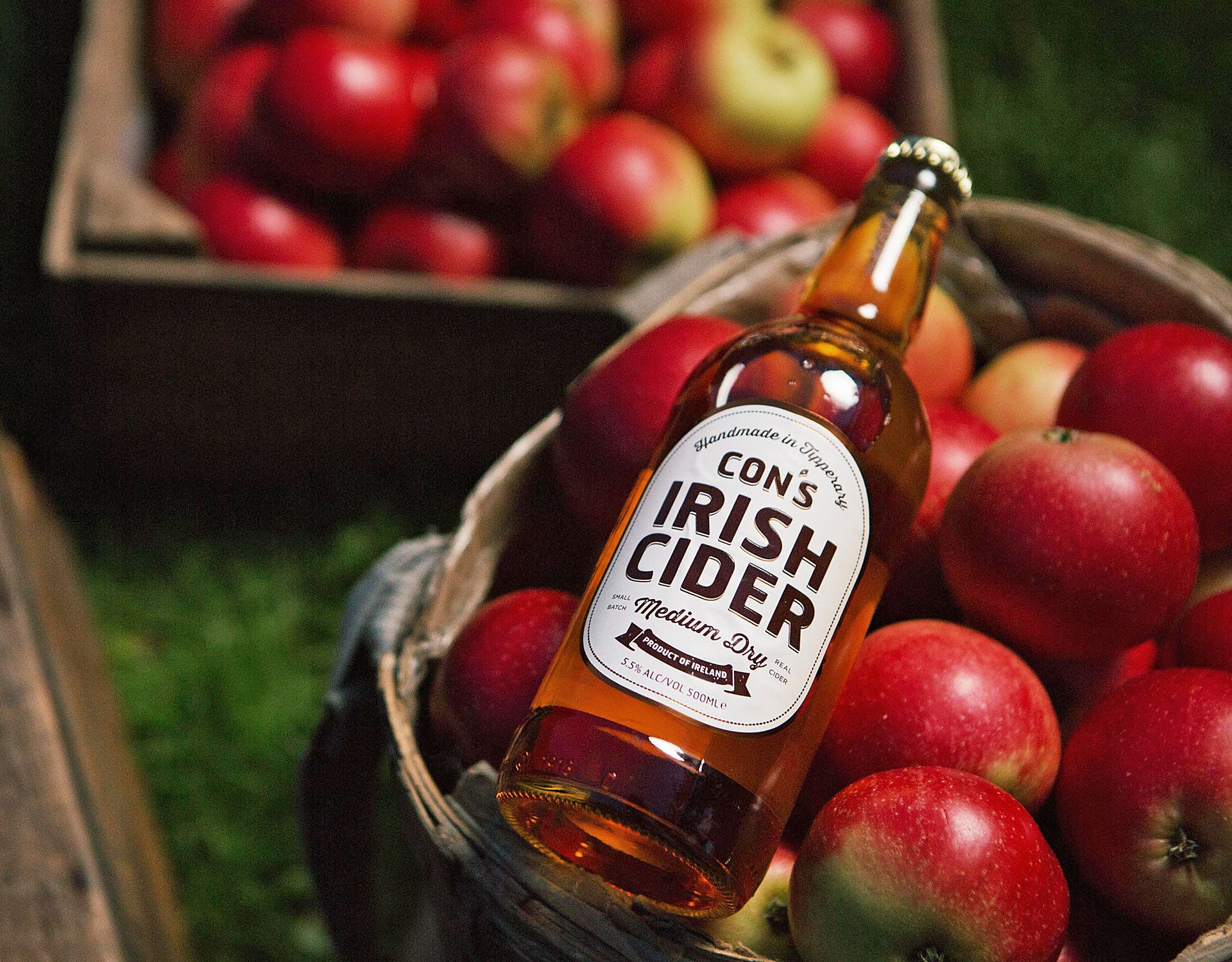 The Apple Farm view of a bottle of cider on a basket of red apples