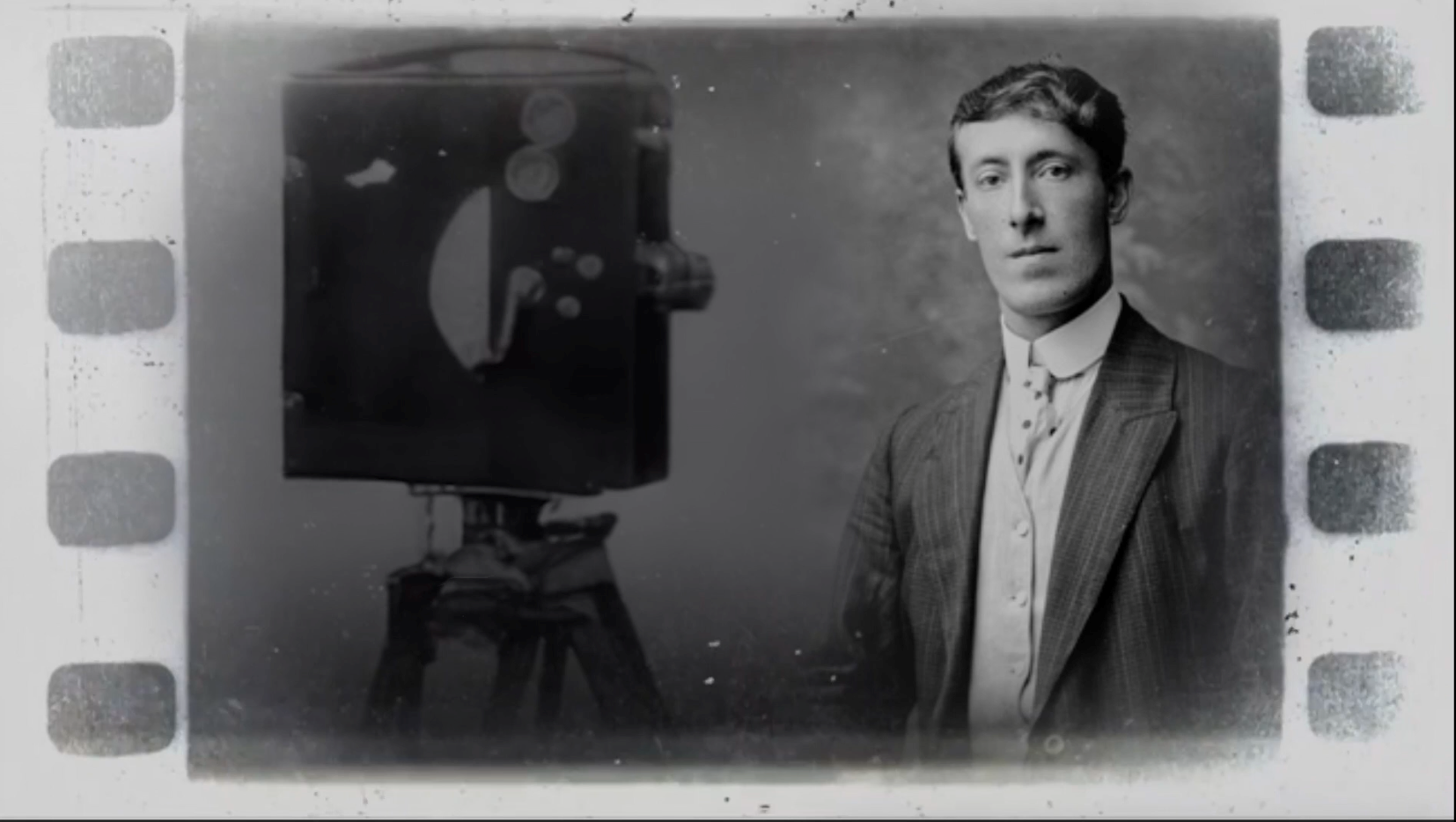A picture of a man next to an old film camera.