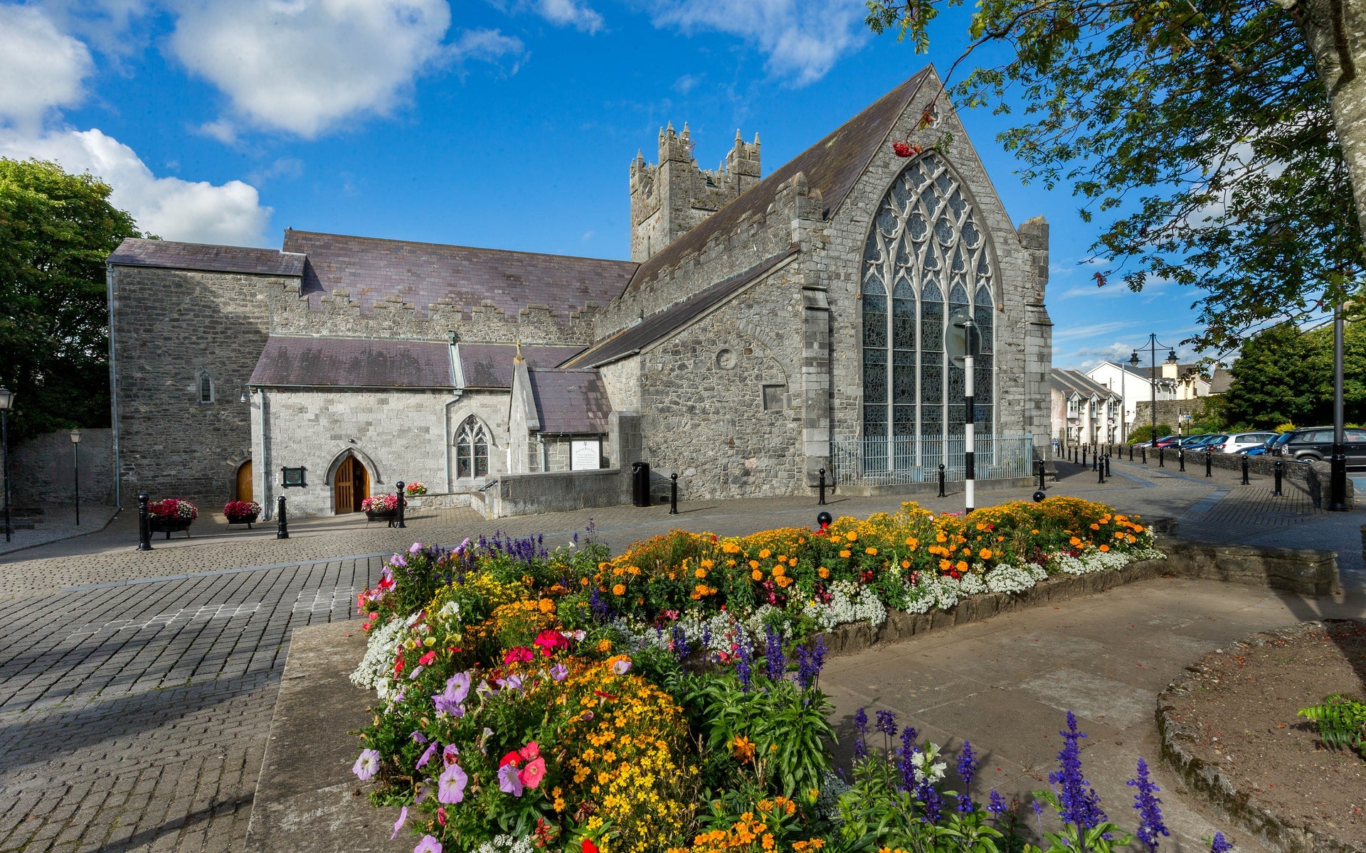 Exterior of The Black Abbey Kilkenny City showing the Rosary Window from the outside with flower beds to the front of the picture