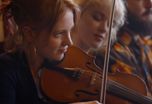 Close up view of young woman playing a violin