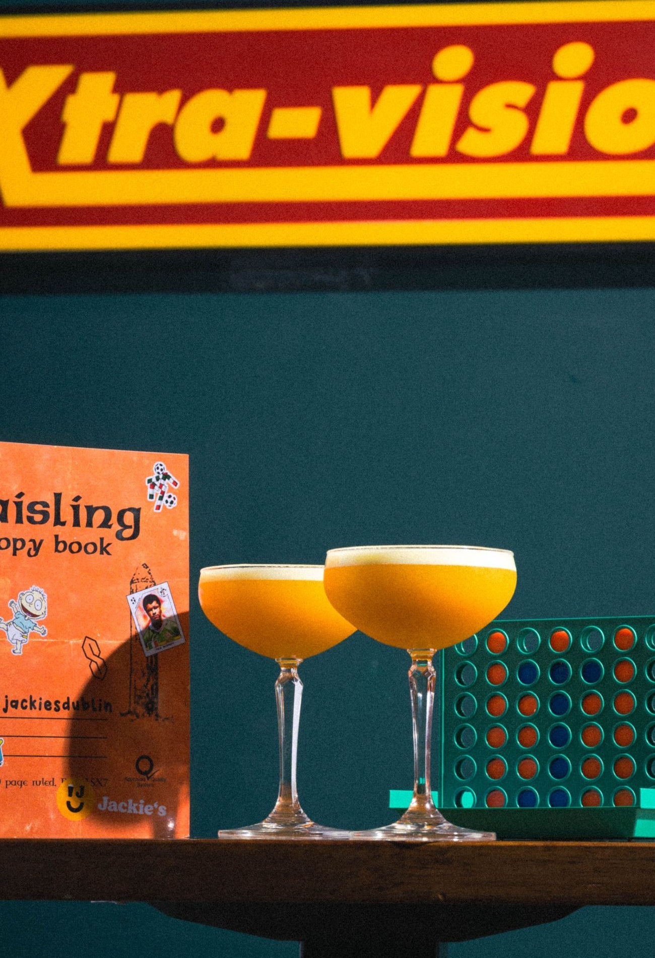 Two glasses of a Solero inspired cocktail with a retro backdrop